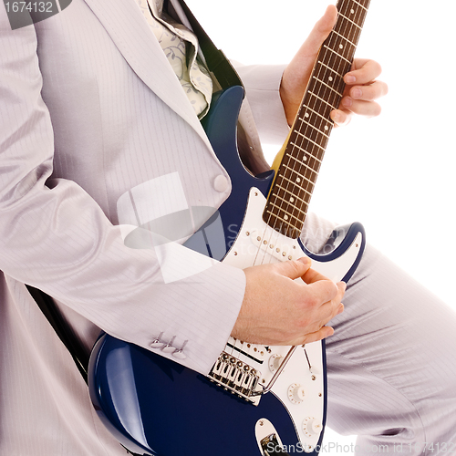 Image of man in white suit playing guitar