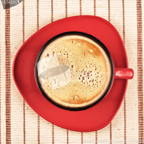 Image of red coffee cup on striped tablecloth