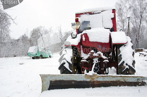 Image of old russian soviet tractor covered snow in winter 