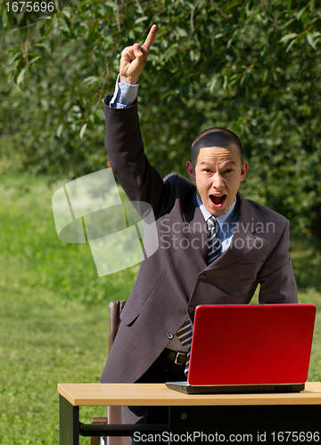 Image of man with red laptop working outdoors