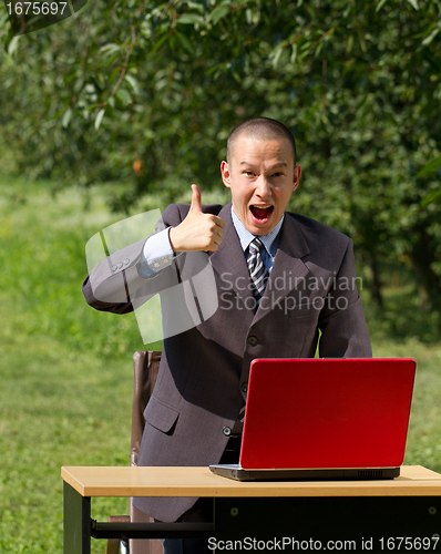 Image of man with red laptop working outdoors
