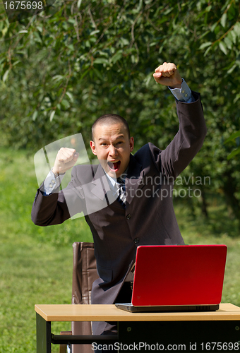 Image of man with red laptop working outdoors