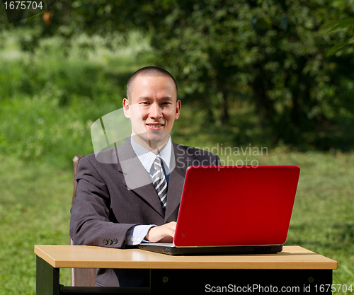 Image of man with laptop working outdoors