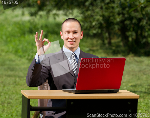 Image of man with laptop working outdoors