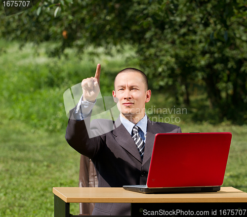 Image of man with laptop working outdoors