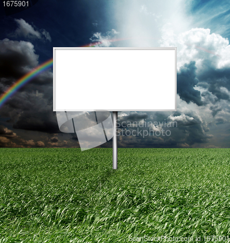 Image of billboard and green grass and blue cloudly sky