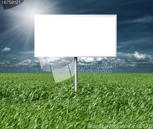 Image of billboard and green grass and blue cloudly sky