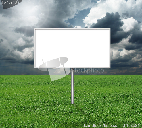 Image of billboard and green grass and blue cloudly sky