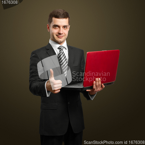 Image of male in suit with laptop in his hands