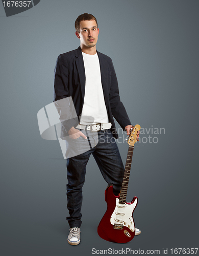 Image of stylish man with guitar looking at camera