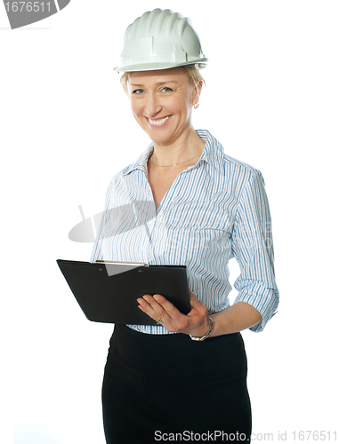 Image of Smiling female architect holding documents
