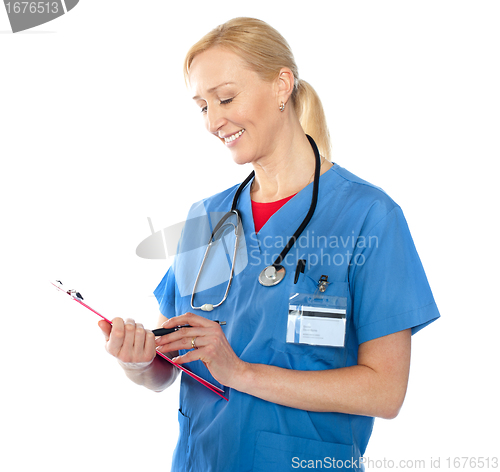 Image of Senior female doctor writing report