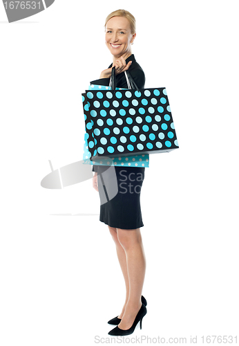 Image of Beautiful woman standing with shopping bag