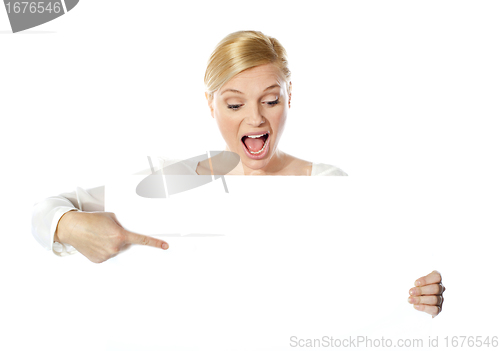 Image of Gorgeous woman pointing at blank clipboard