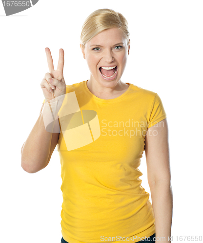 Image of Young and beautiful teenage girl doing victory sign