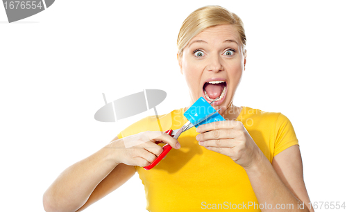 Image of Excited female cutting her credit card