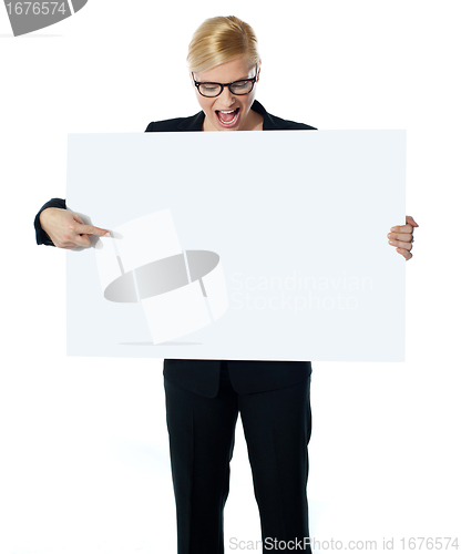 Image of Successful business female pointing at white blank billboard