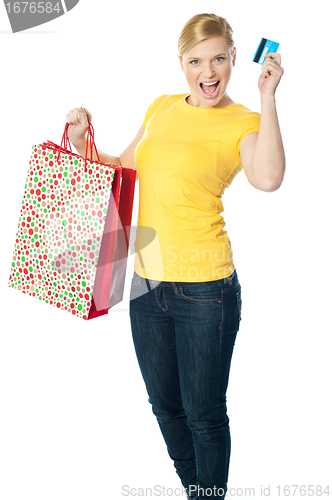 Image of Happy shopaholic girl showing credit card