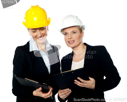 Image of Young female architects reviewing documents