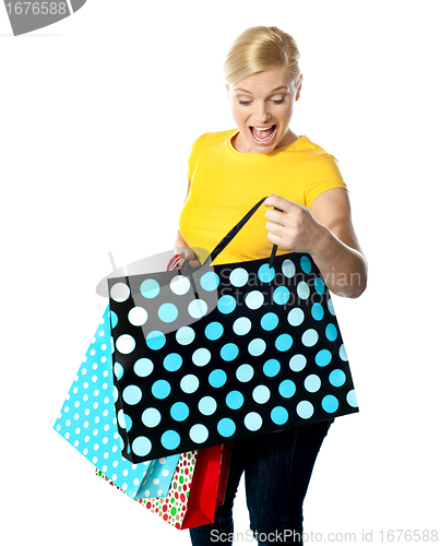 Image of Young girl looking excitedly inside her shopping bag