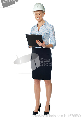 Image of Elderly female architect studying file