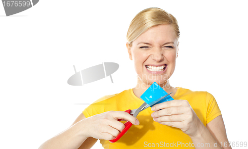 Image of Woman grinding teeth while cutting her credit card