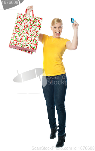 Image of Excited teenager holding shopping bag and card