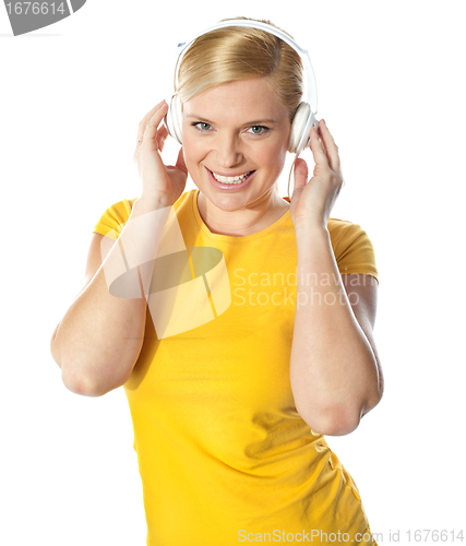 Image of Smiling young lady listening music