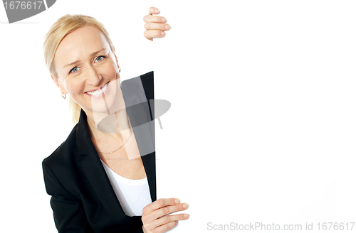 Image of Smiling aged female executive holding clipboard