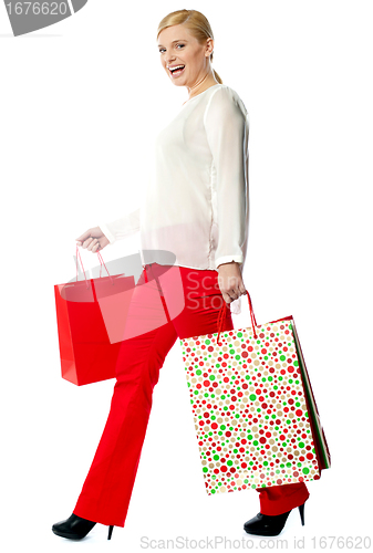 Image of Pretty woman with shopping bags, walking