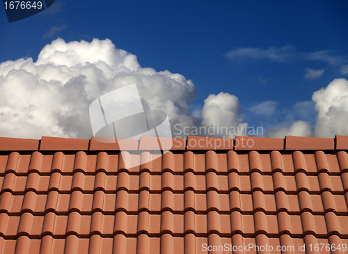 Image of Roof tiles and blue sky with clouds