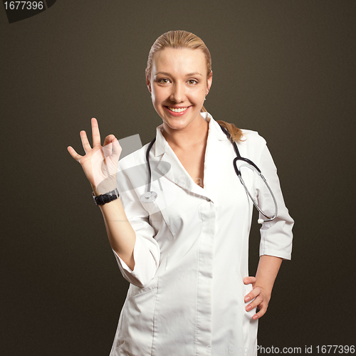 Image of young doctor woman shows ok