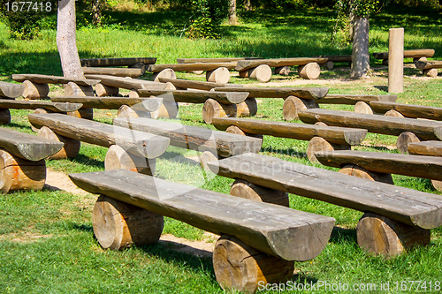 Image of outdoor wood benches on green lawn