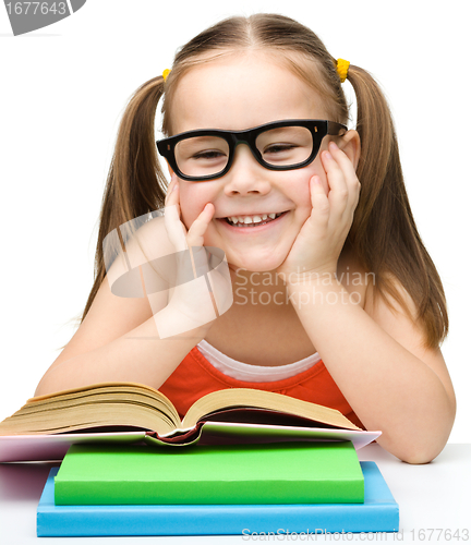 Image of Cute little girl reads a book