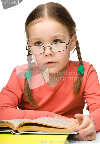 Image of Cute little girl reads a book
