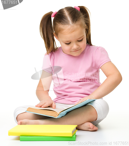 Image of Cute little girl reads a book