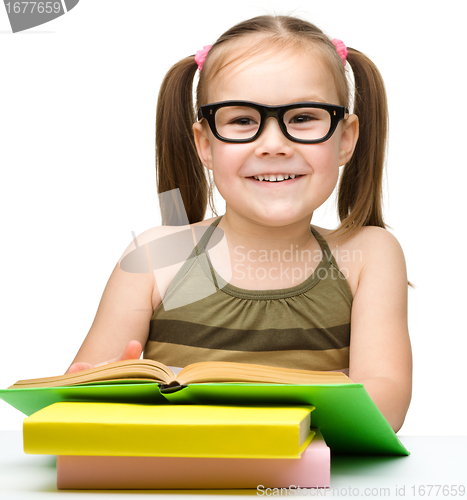 Image of Cute little girl reads a book