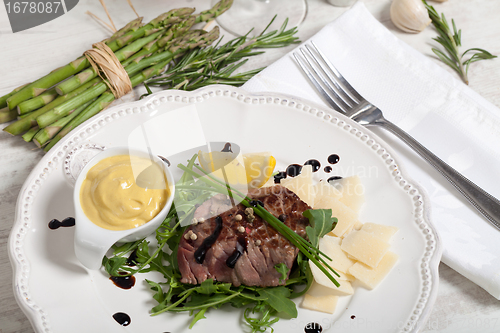 Image of Beef on arugula salad and parmesan