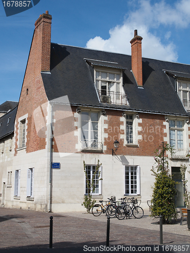 Image of Bicycles in front of a white tuff, red brick and blue slate buil