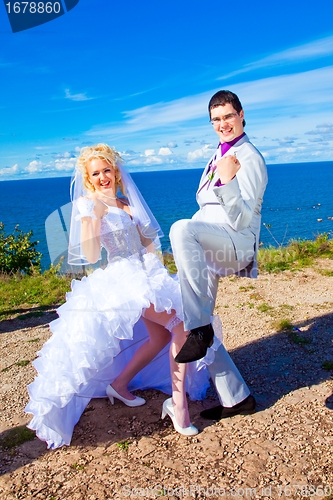 Image of  happy groom and bride on a sea coast