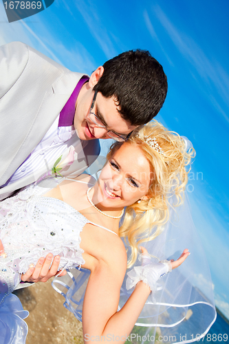 Image of happy groom and bride on a sea coast