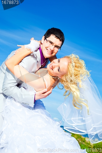 Image of happy groom and bride on a sea coast