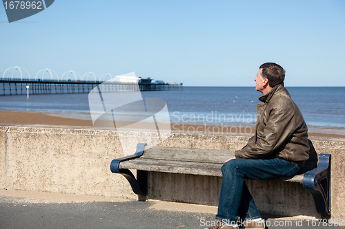 Image of Senior man looking out over beach at Southport