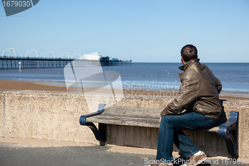 Image of Senior man looking out over beach at Southport