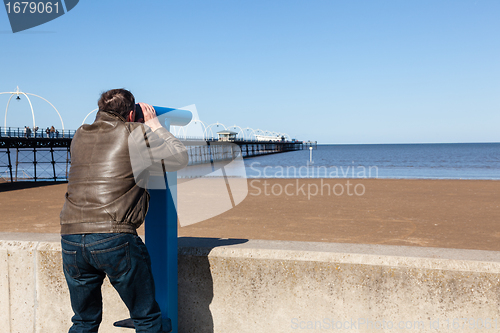 Image of Senior man looking out over beach at Southport