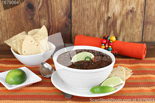 Image of Black bean mexican soup with chips and lime.