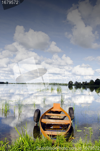 Image of Lake boat moored tires cloud reflection on water 