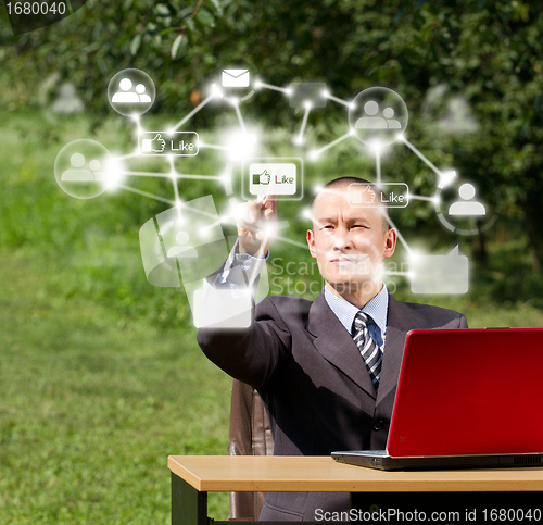 Image of Man with Laptop Working Outdoors in Social Network