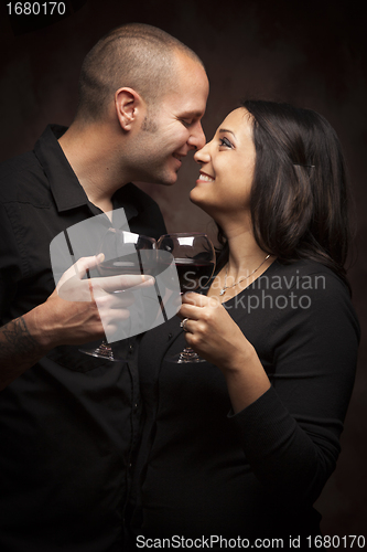 Image of Happy Mixed Race Couple Flirting and Holding Wine Glasses