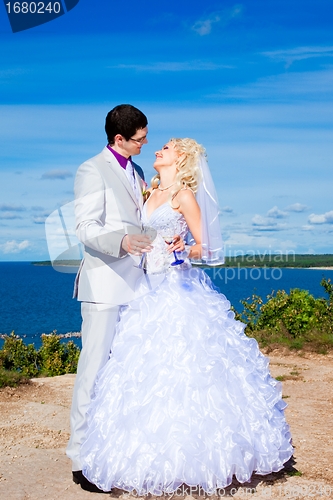 Image of  happy groom and bride on a sea coast